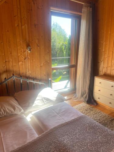 a bedroom with a bed next to a window at Domki Florentyna Szklarska Poręba-Wojcieszyce in Wojcieszyce