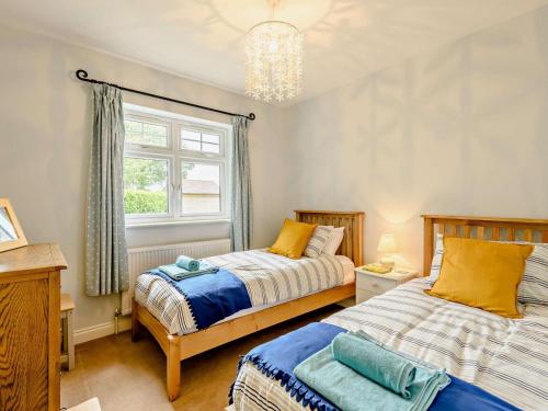 two beds in a bedroom with a window at 2 Bed in Blandford Forum oc-83814 in Morden