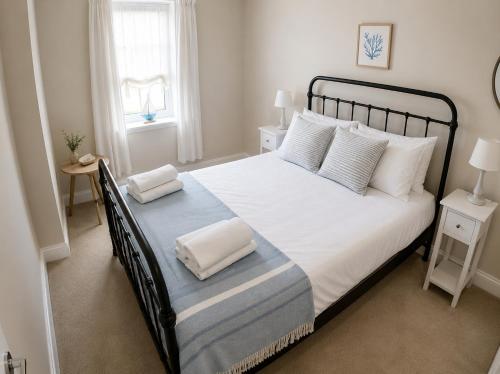a bedroom with a large bed with white sheets and pillows at Storm View in Castletown