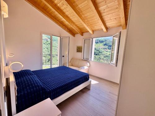 a bedroom with a bed and two windows at House Over The Paradise in Moneglia
