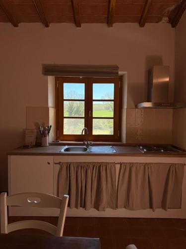 a kitchen with a sink and a window at Agriturismo Podere Santo Stefano in Cinigiano