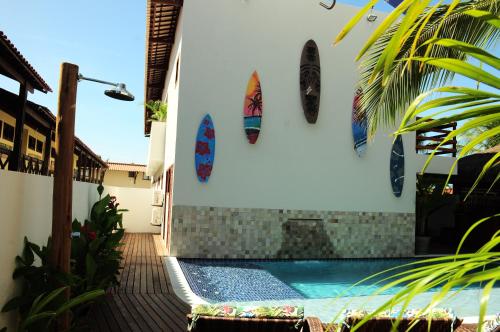 a swimming pool with surfboards on the side of a house at Pousada Waikiki Boutique in Pipa