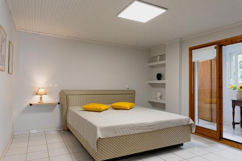 a bedroom with a bed with yellow pillows on it at Arches in Agria