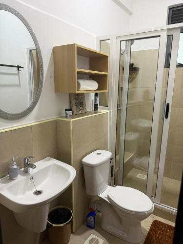 a bathroom with a toilet and a sink and a shower at ValdOrea Residences in Entebbe