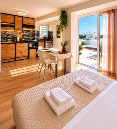 a bedroom with a bed and a table and a kitchen at Dorian in Kos