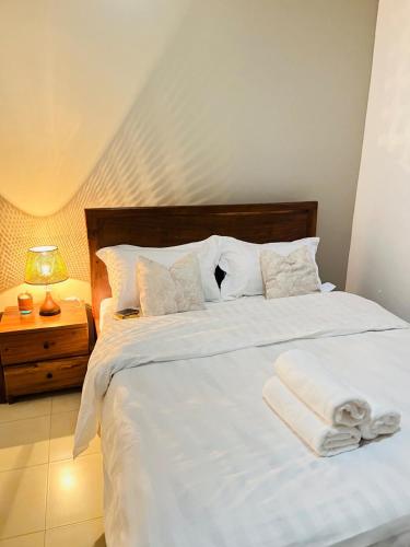 a bedroom with a white bed with towels on it at ValdOrea Residences in Entebbe
