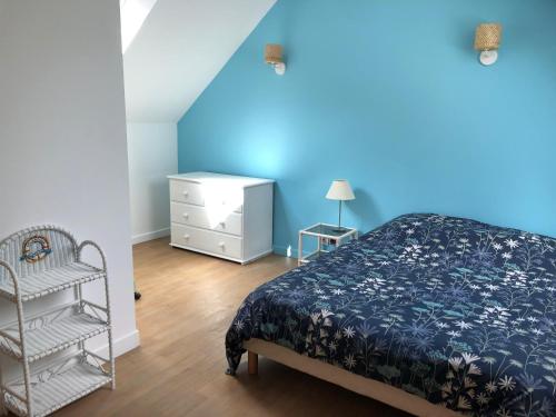 a bedroom with a bed and a blue wall at Gîte entre l'océan et le golfe in Surzur