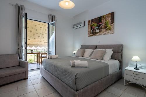 a bedroom with a bed and a chair and a window at Aspasia Studios in Lixouri