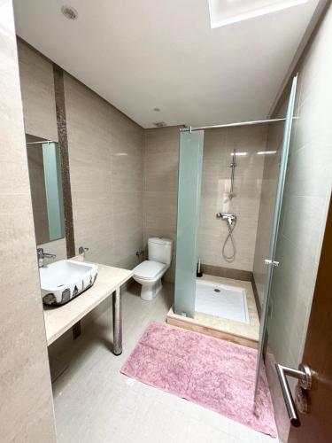 a bathroom with a shower and a sink and a toilet at Cozy Seaside Villa in Bir Jedíd Saint-Hubert