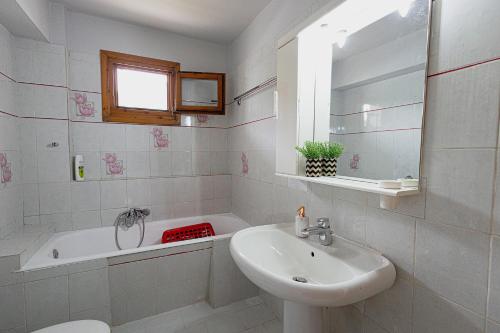a white bathroom with a sink and a tub and a sink at Arches in Agria