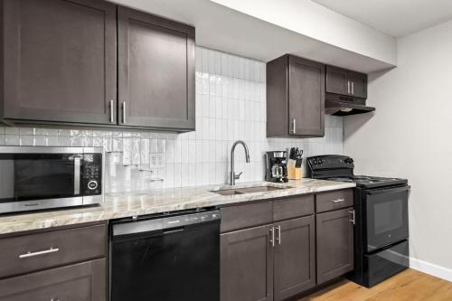 a kitchen with stainless steel appliances and brown cabinets at Newly Renovated Unit in Central Spfld #203 in Springfield