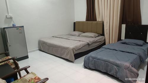a bedroom with two beds and a mirror at AZ Guest House & Inn in Pasir Mas