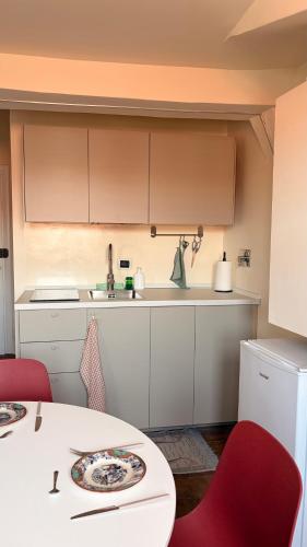 a kitchen with a table and red chairs and a counter at Asterisco Casa Vacanze in Turin