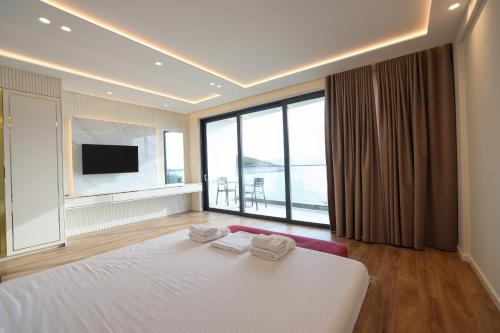 a bedroom with a large bed with two towels on it at Palmera Dream Vila in Sarandë