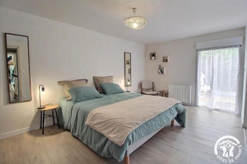a bedroom with a large bed and a large window at Du rocher in Plélo