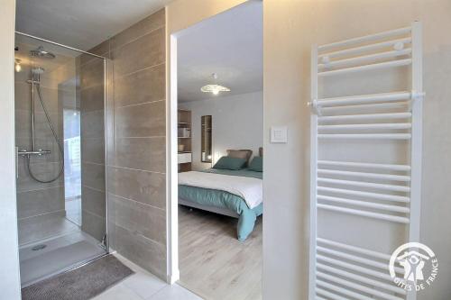 a bathroom with a shower and a bed in a room at Du rocher in Plélo