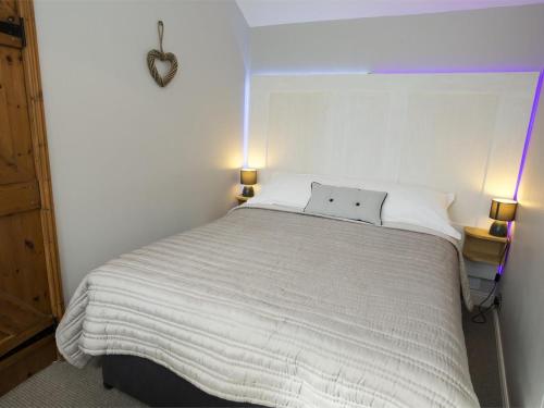 a bedroom with a large white bed with two lamps at 1 Bed in Ripon oc-g0023 in Winksley