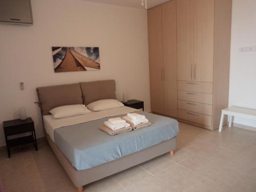 a bedroom with a bed with towels on it at Lefka's Villas in Vivari