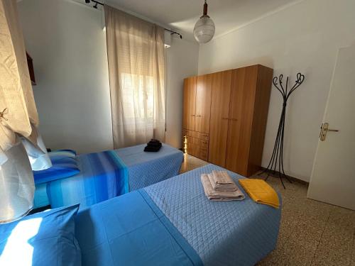 a bedroom with two blue beds and a cabinet at Affittacamere VITRUVIO in Fano