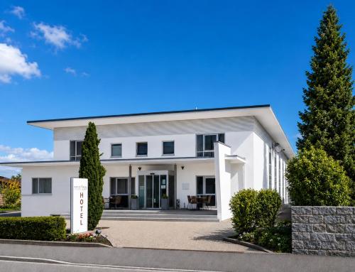 a white house with trees in front of it at Hotel Garni Max Zwo in Dingolfing