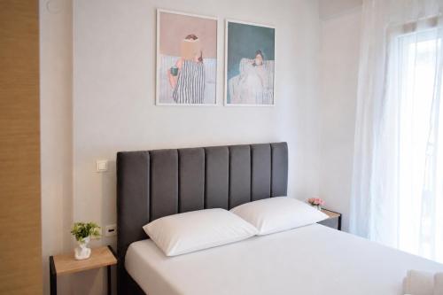 a bed with a black headboard in a bedroom at Emmeleia Urban Apartment in Xanthi