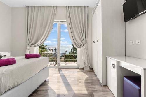 a bedroom with a bed and a large window at Villa Manuela in Opatija