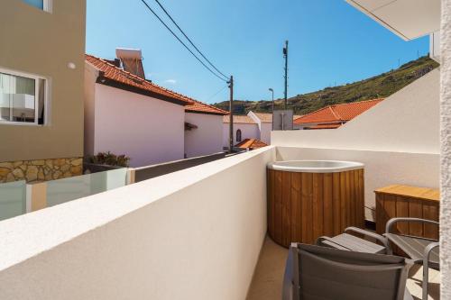 a balcony with chairs and a table on a building at GuestReady – Steps from Sand • Champagne Pool in Machico