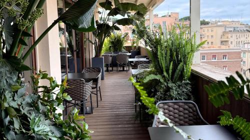a balcony with tables and chairs and plants at Radisson Blu GHR Rome in Rome