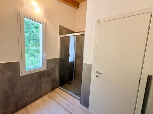 a bathroom with a shower and a glass door at House Over The Paradise in Moneglia