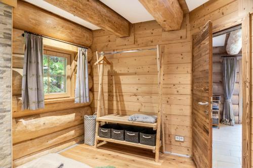 a log cabin bathroom with wooden walls and a window at Chalet Weiss in Wörgl
