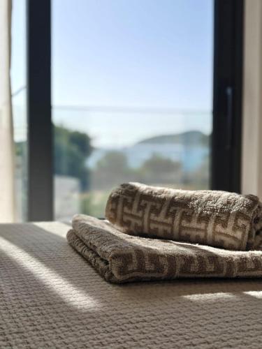 two towels sitting on a table with a window at Aura Mare in Porto Rafti
