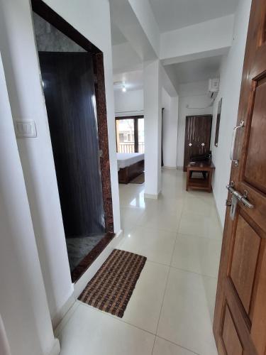 a hallway with a door and a large mirror at Prakash Holiday Inn in Arambol