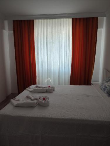 a bed with two pairs of slippers on top of it at Umut's Hause in Bezkesen