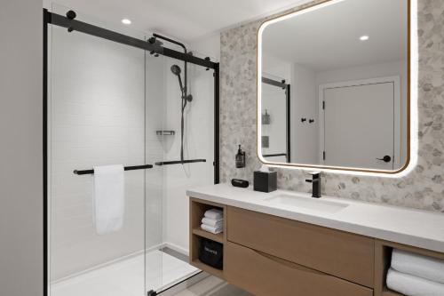 a bathroom with a shower and a sink and a mirror at Hotel Indigo North Conway by IHG in North Conway