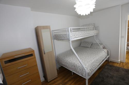 a bedroom with a bunk bed and a dresser at Tideslea Riverview Apartment in Plumstead