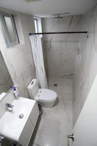 a white bathroom with a toilet and a sink at Departamento en el corazón de angelópolis in Puebla