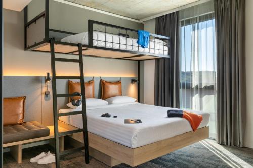a bedroom with two bunk beds and a window at Moxy Wuerzburg in Würzburg