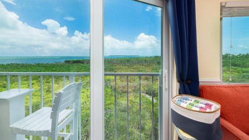 a balcony with a chair and a view of the ocean at Sunrise Penthouse 3316 Ocean Pointe 1BR 2BA in Tavernier