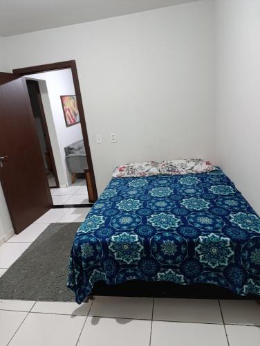 a bedroom with a bed with a blue quilt at Casa indaial in Indaial