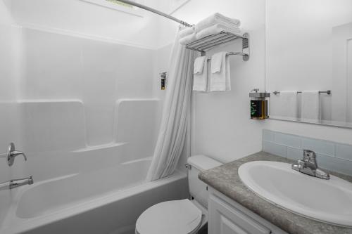 a white bathroom with a sink and a toilet at Sun Outdoors Petoskey Bay Harbor in Petoskey
