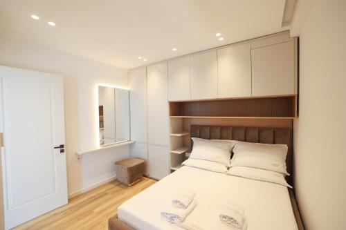 a bedroom with a large bed with a wooden headboard at Palmera Prive Vila in Sarandë
