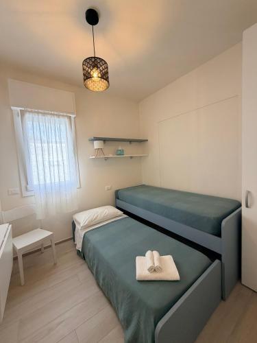 a small bedroom with two beds and a window at Modern Sea Apartment in Punta Marina