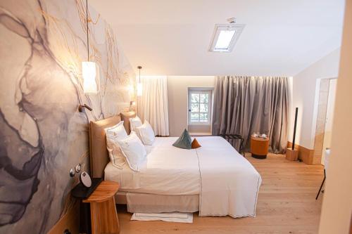 a hotel room with a bed and a painting on the wall at Aux ducs de Sienne in Montagne