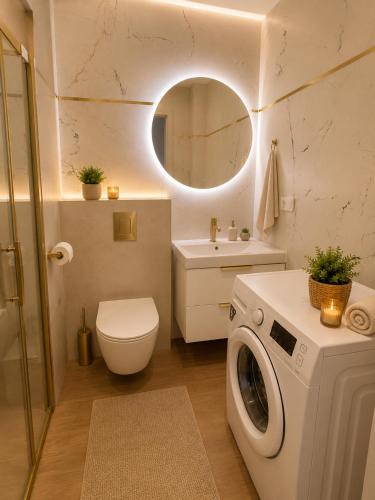 a bathroom with a washing machine and a toilet at Family Spot in Konin