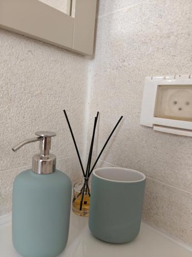 a bathroom counter with a soap dispenser and a cup at לנשום בצוקים in Zuqim