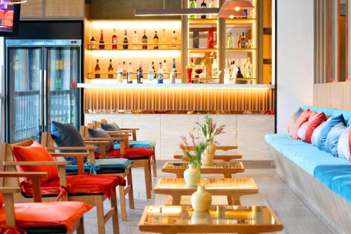 a restaurant with chairs and tables and a bar at Coco Beach Hotel Jomtien Pattaya in Jomtien Beach