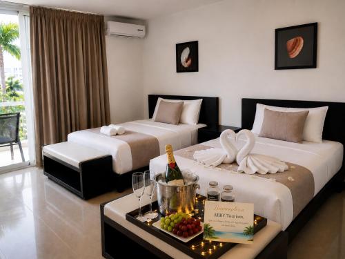 two beds in a hotel room with a tray of food at Blue Diamond Suite de playa in Playa Blanca