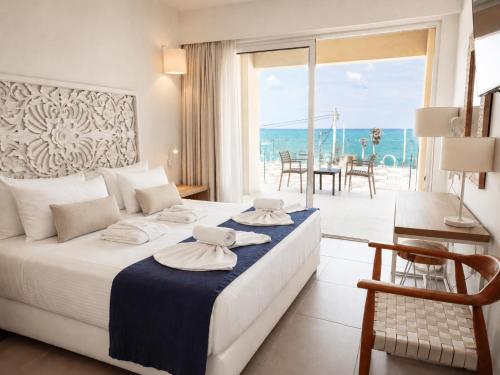 a bedroom with a bed with a view of the ocean at St Constantin Sea Hotel & Spa Resort in Gouves