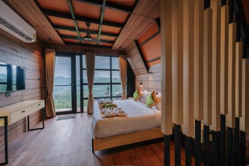 a bedroom with a large bed and a large window at Cliff and Cloud Vagamon in Vagamon