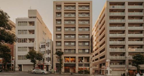 an apartment building with a car parked in front of it at Nesthotel Alt Meguro Ekimae in Tokyo